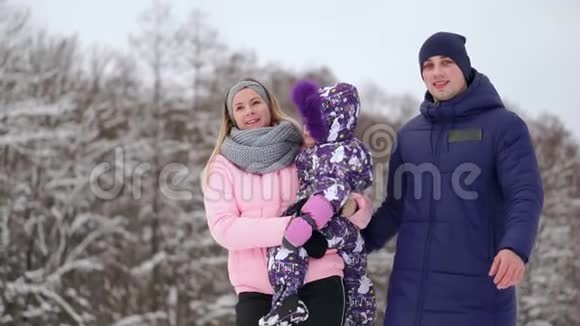 日落时幸福的家庭爸爸妈妈和两个女儿玩得很开心在下雪的冬天散步视频的预览图