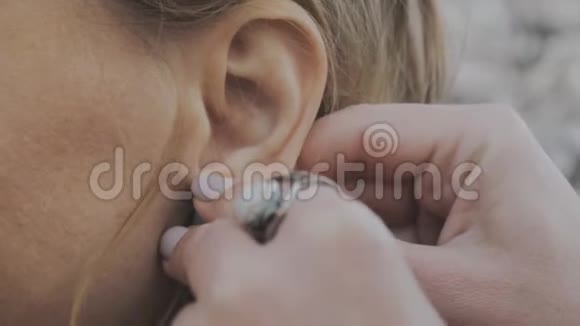户外手工耳环上的女性手的特写视频的预览图