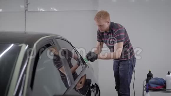 洗车站的专业工人用抛光机仔细抛光干净的汽车视频的预览图