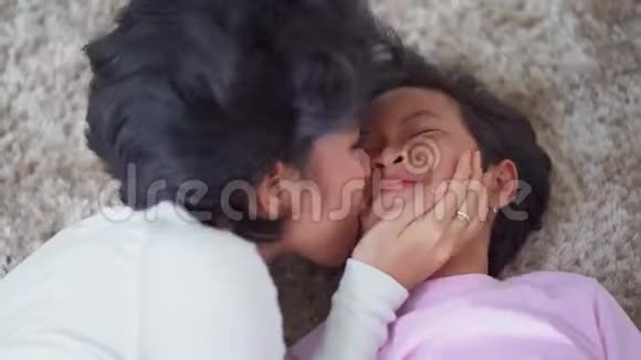 年轻女子在地毯上亲吻女儿视频的预览图