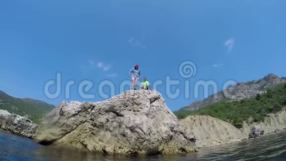 女孩从岩石跳到水里慢动作视频的预览图