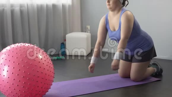 有趣的懒女孩躺在大健身球上不能做减肥运动视频的预览图