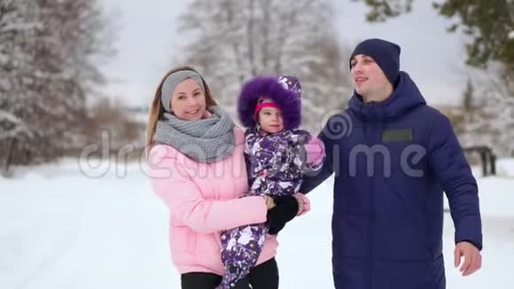 日落时幸福的家庭爸爸妈妈和两个女儿玩得很开心在下雪的冬天散步视频的预览图