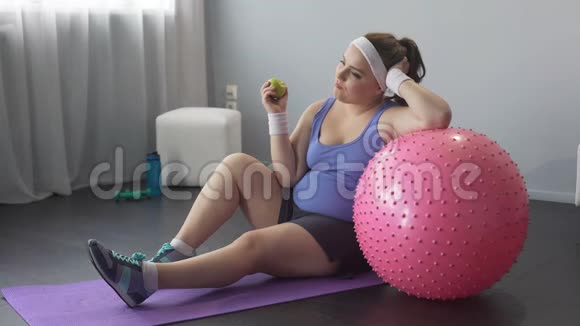 运动女孩嚼苹果梦想着理想的身材减肥食谱视频的预览图
