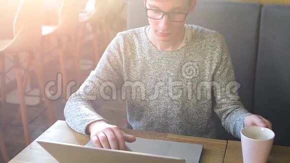 年轻的自由职业者在笔记本电脑咖啡馆工作视频的预览图