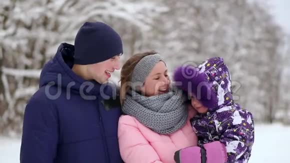 日落时幸福的家庭爸爸妈妈和两个女儿玩得很开心在下雪的冬天散步视频的预览图