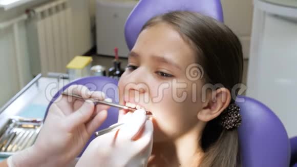 特写4k镜头牙医戴乳胶手套检查女孩嘴视频的预览图