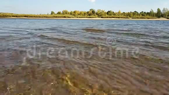 波浪在河的沙岸上奔跑阳光明媚的一天视频的预览图