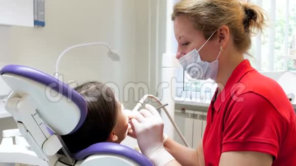 特写4k镜头牙科医生治疗女孩牙齿和消除龋齿视频的预览图