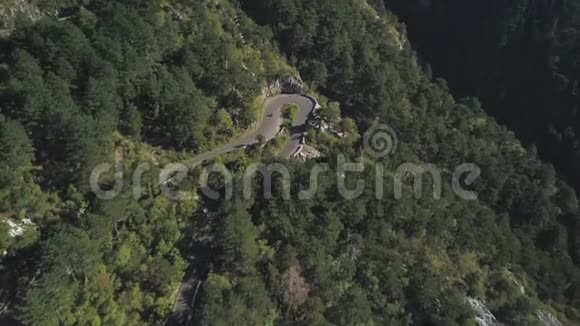 骑着摩托车和一辆汽车在华丽茂盛的森林山坡上驰骋穿过起伏的道路视频的预览图