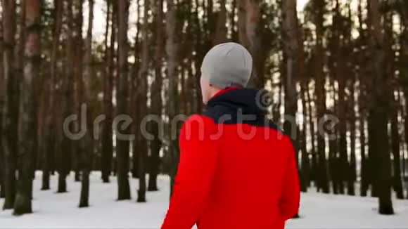穿着红色夹克衫的跑步者穿着休闲服装穿过森林一个大的帕潘相机显示腿和视频的预览图