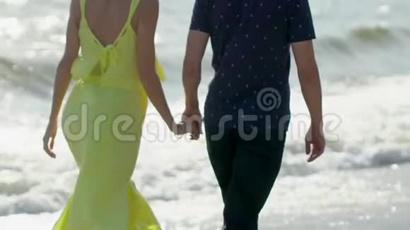 新婚夫妇牵着手一起享受旅游假期快乐假期海滩上的男人和女人视频的预览图