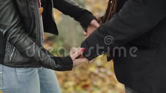 一对年轻夫妇牵着手站在公园里看着他们的眼睛开心地笑着视频的预览图