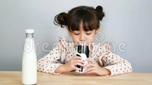 4K可爱的女孩喝着鲜奶的肖像脸很滑稽视频的预览图