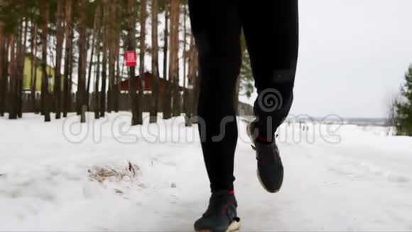 一个穿着红色夹克衫的年轻人穿着休闲服装穿过森林前景Kamemra离开视频的预览图