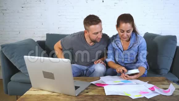 年轻的幸福夫妇用笔记本付账单视频的预览图