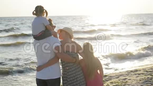 英俊的父亲和迷人的母亲两个女儿在日落时一起在海边度过时光男子手持视频的预览图
