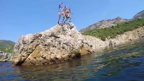 三个人牵着手从悬崖上跳水慢动作视频的预览图