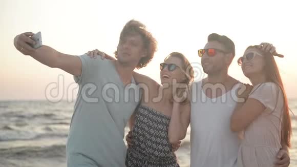 四人白托西笑着用手机消磨时间在海边的画像视频的预览图