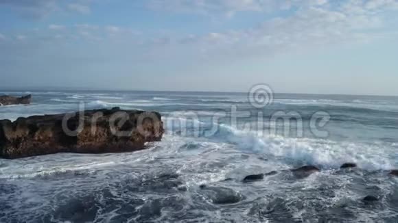 鸟瞰美丽的海浪拍打着巴厘岛的岩石视频的预览图
