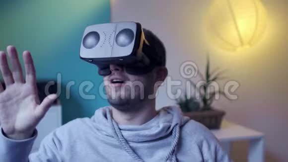 穿着懒包的男人在家中虚拟现实谷歌vr上起飞和享受虚拟现实视频的预览图