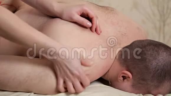 男人在按摩台上放松接受按摩按摩师在水疗沙龙里按摩人体美容治疗视频的预览图