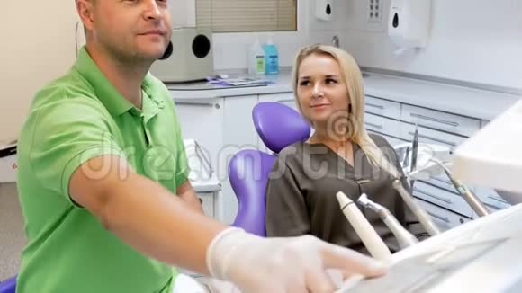 牙科医生在牙齿治疗后将病人抬椅子上的4k镜头视频的预览图