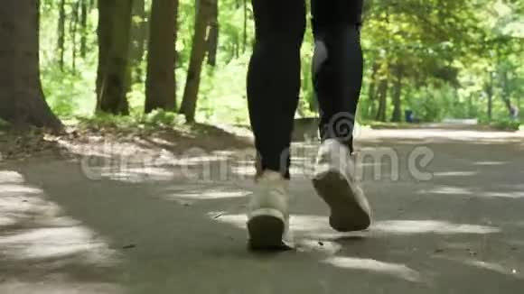 在公园慢跑50英尺高的跑鞋里将女性的腿收起来视频的预览图