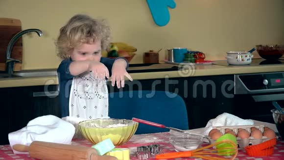 情绪化的女孩在厨房里弄面粉有趣的孩子拍手大笑视频的预览图