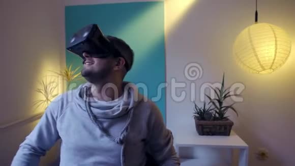 穿着懒包的男人在家中虚拟现实谷歌vr上起飞和享受虚拟现实视频的预览图