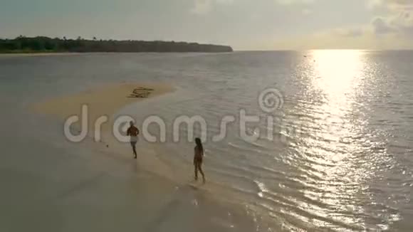 带海星的空中热带沙洲和日落时分在沙洲上散步的旅行情侣视频的预览图