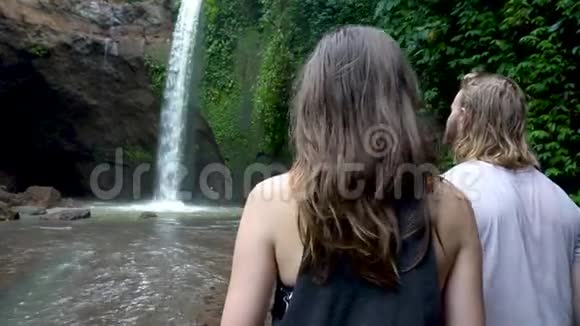 徒步旅行者男女在森林中探索瀑布在巴厘岛徒步旅行视频的预览图