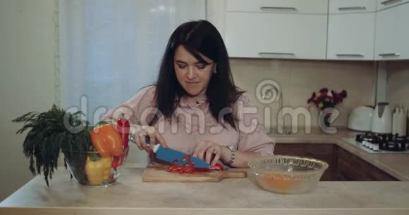 幸福的女人切菜准备食物的背景是白色的厨房视频的预览图