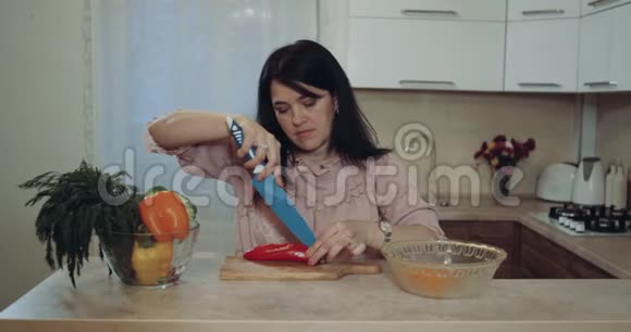 厨房里的女人准备蔬菜让食物开心她切了它们4k视频的预览图