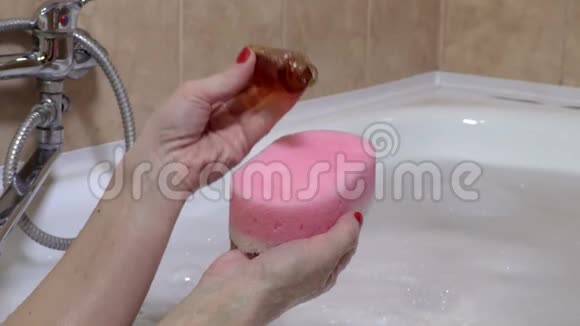 女人把洗发水放在海绵上视频的预览图