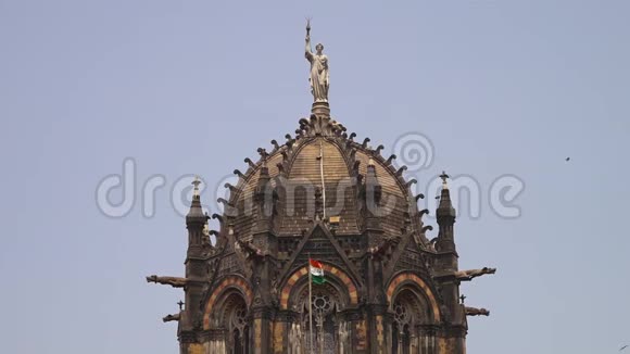 一座雕像坐落在一座古老的印度寺庙的顶部俯瞰着这片土地视频的预览图