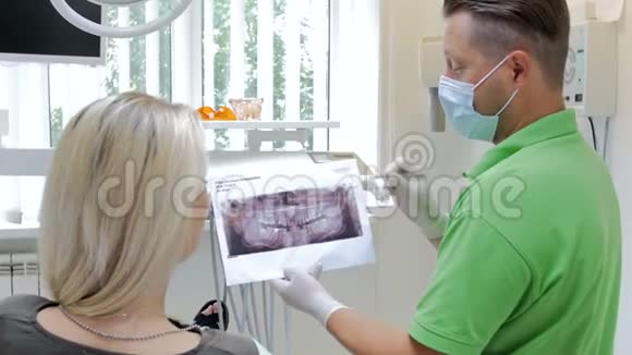 4k段牙医讲解牙齿治疗并向病人展示x光图像视频的预览图