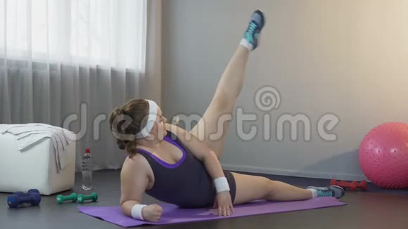 女运动员伸直双腿躺在家里的瑜伽垫上渴望减肥视频的预览图