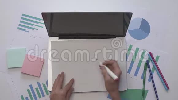商业概念女人在电脑上的一张纸上写字视频的预览图