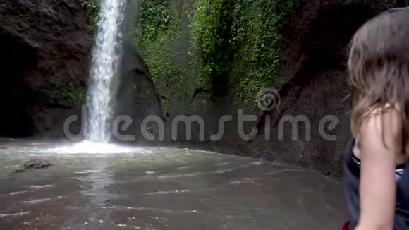 旅行的概念巴厘岛瀑布附近张开双臂的女性视频的预览图