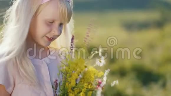 可爱的小女孩享受大自然看着一束野花视频的预览图