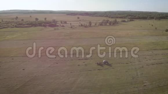 田间干草拖拉机的空中视野干草堆在拖车里农业工作的概念视频的预览图