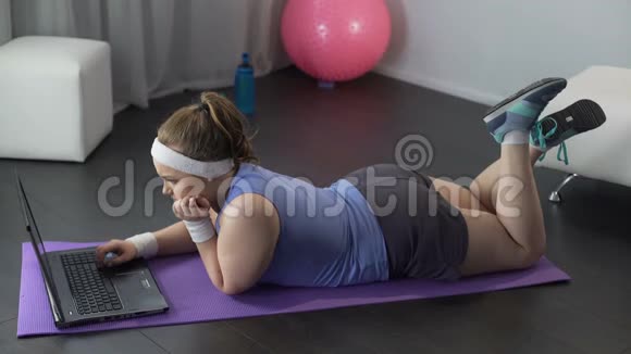 胖女孩在笔记本上看健身课准备运动锻炼视频的预览图