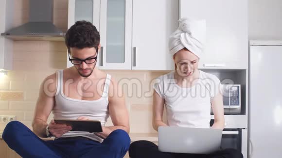 年轻的商务夫妇穿着家庭服装在家工作并享受成功的销售视频的预览图
