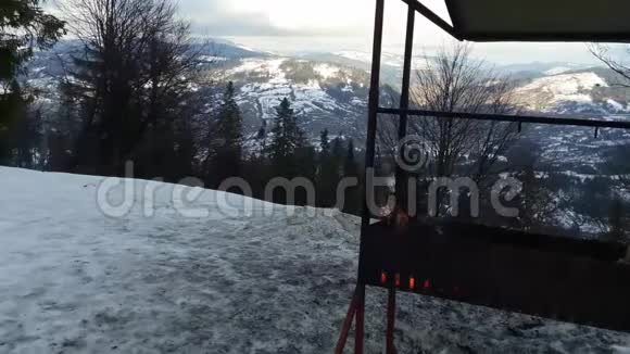 一座雪山顶上白雪皑皑的布拉齐尔燃烧着的木头视频的预览图