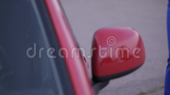 一个穿着蓝色西装的女人走近红色的车打开车门视频的预览图