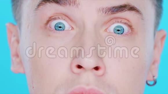 在蓝色背景上特写一个男人的脸他的眼睛视频的预览图