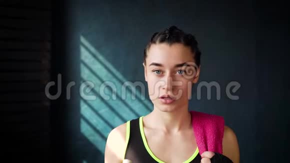 健身妇女在健身房用毛巾休息从健身和饮水瓶视频的预览图