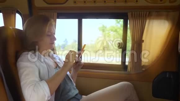 一个女人坐在小货车的乘客座位上使用电话视频的预览图