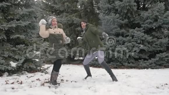 女人和女孩在冬天的森林里玩雪球美丽的风景和雪杉树视频的预览图